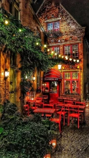 Evening Coziness of a Belgian Courtyard: Red Chairs and Light of Bulbs