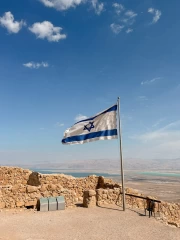 Proud Flag of Israel: Symbol of the Country on the Background of Ancient Stones and Blue Sky