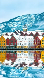 Vibrant Norwegian Homes by Calm Water and Snowy Mountains