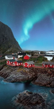 Northern Lights over the Red Houses of Norway: The Atmosphere of Scandinavia